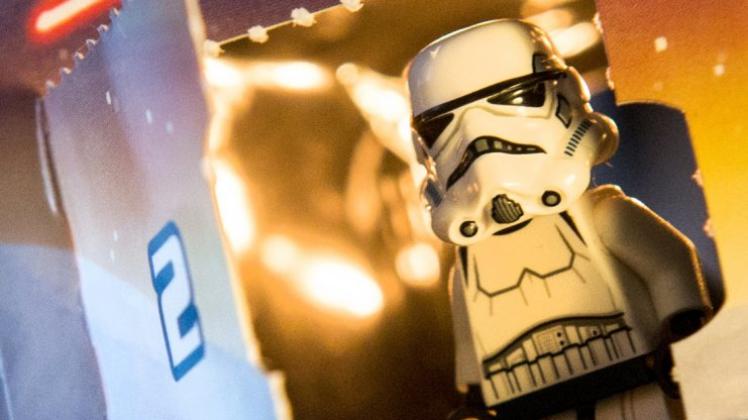 Eine Stormtrooper-Figur schaut aus dem Kalendertürchen eines „Star Wars“-Adventskalenders von Lego. 
