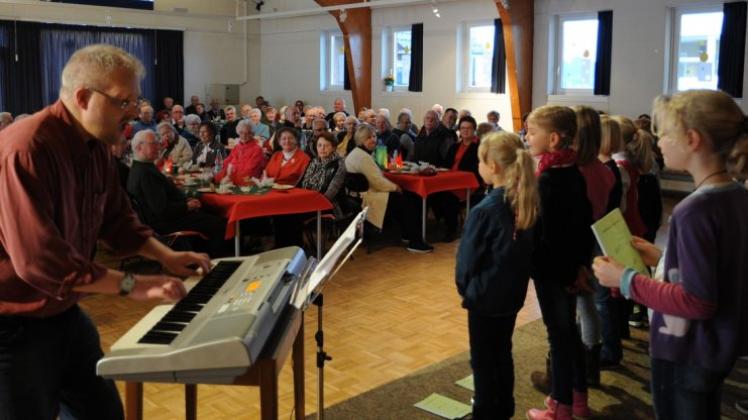 Der Kinderchor „Flotte Noten“ unter der Leitung von Martin Stindt (links) begeistert sein Publikum mit Weihnachtsliedern. 