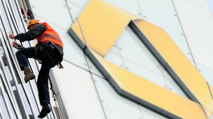 Ein Fassadenkletterer hängt vor dem Logo der Commerzbank in Frankfurt. Ein Fassadenkletterer hängt vor dem Logo der Commerzbank in Frankfurt.