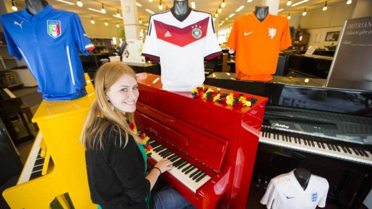 Hast du Töne! Annika Tammen (27), Tochter von Rohlfing-Geschäftsführer Wilfried Tammen, präsentiert die drei „Deutschland“-Klaviere im Schaufenster des Osnabrücker Musikinstrumente-Geschäfts. 