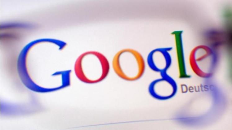 Das Google-Logo ist durch ein Brillenglas auf einem Bildschirm zu sehen. 