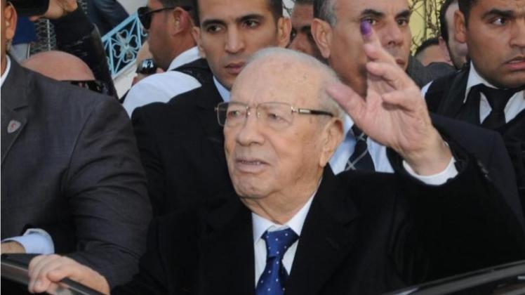 Präsidentschaftskandidat Beji Caid Essebsi zeigt nach der Stimmabgabe seinen mit Tinte markierten Finger. 