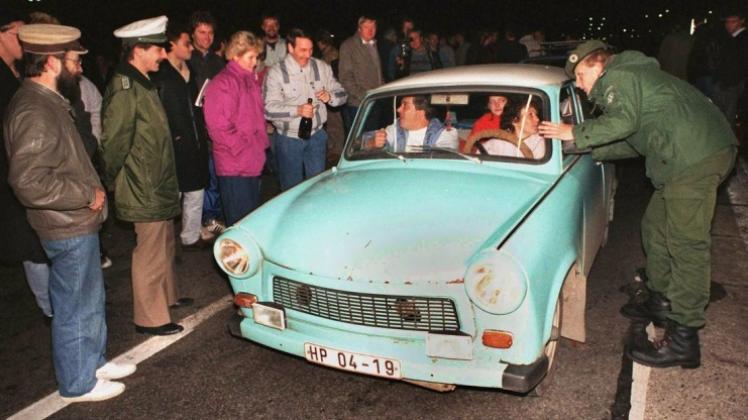 Das Archivbild vom 10.11.1989 zeigt, wie ein Beamter des Bundesgrenzschutzes einem DDR-Autofahrer am Grenzübergang Helmstedt eine Auskunft gibt. 