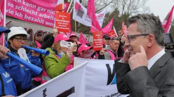 Bundesinnenminister Thomas de Maiziere (CDU, r) geht auf die Demonstranten zu. Der Tarifstreit ist beigelegt. 