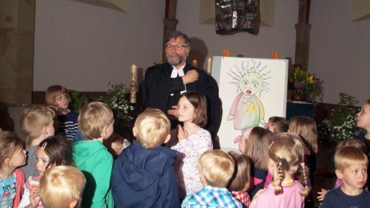 Superintendent Hans Hentschel und Kindergartenkinder verwandelten in der Marienkirche eine „graue“ in eine farbige, lebensfrohe Frau.