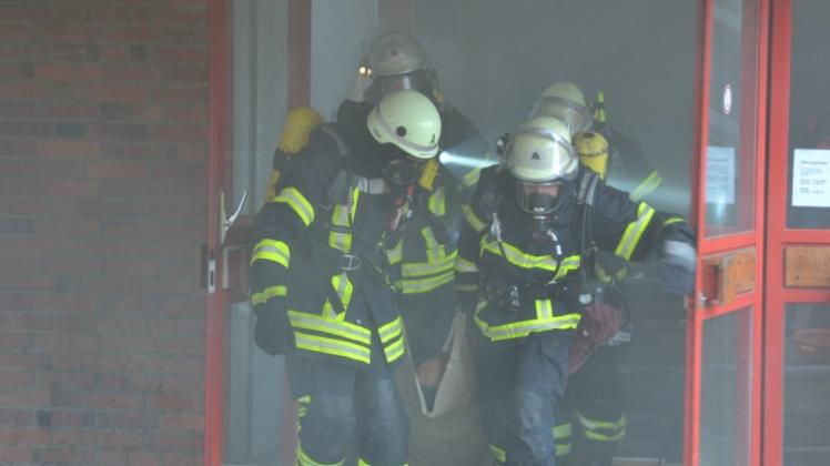 Atemschutzträger der Feuerwehr Lingen bergen einen „Verletzten“ aus einem stark verqualmten Gebäude der ehemaligen Schule Am Wall Süd in Lingen. 