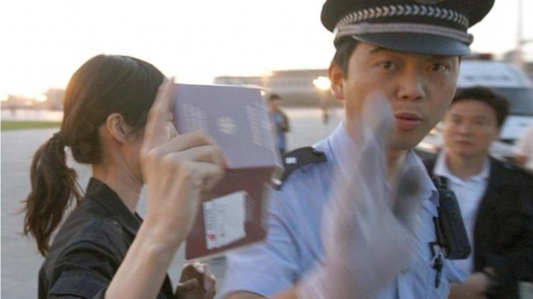 Ein chinesischer Polizist hält Journalisten auf dem Tian&apos;anmen-Platz davon ab, eine Passkontrolle näher zu fotografieren. 