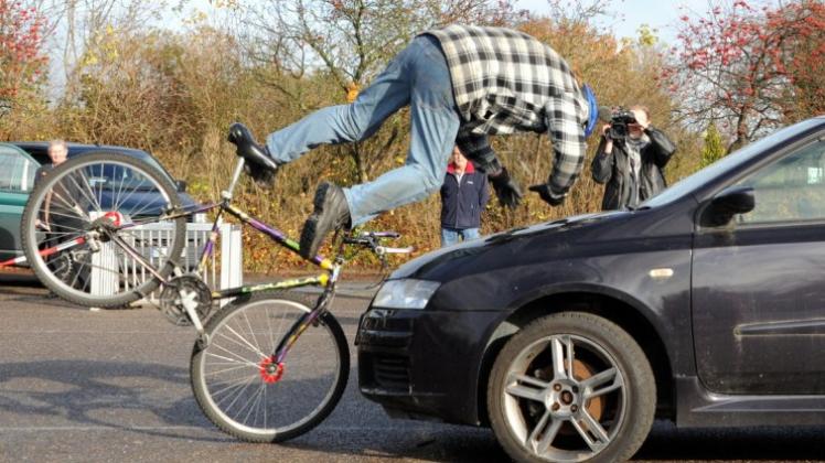 Ein Stuntfahrer demonstriert in Kronshagen bei Kiel den Aufprall mit einem Fahrrad auf ein Auto. 