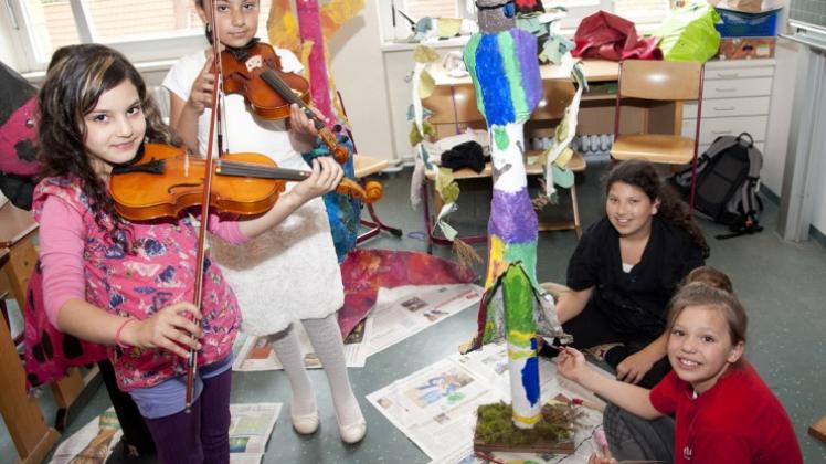 Selbstbestimmt: Die Stüve-Schülerinnen (von links) Irena (9 Jahre) und Fatima lernen Geige, während Angelique (9) und Lucia (10) an Skulpturen arbeiten. 