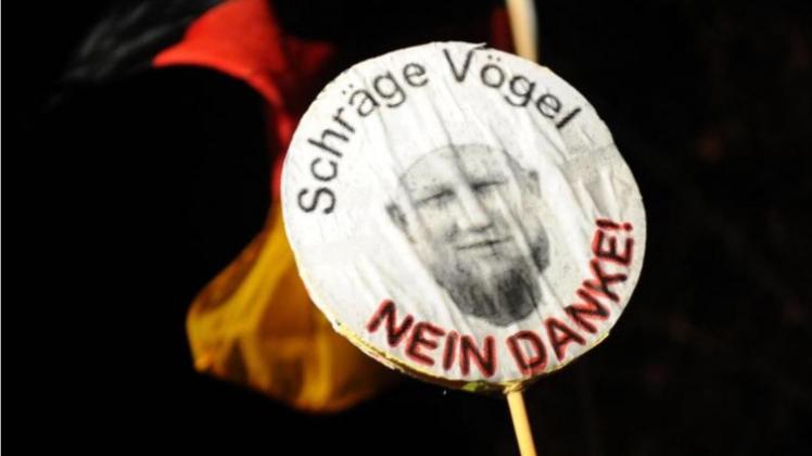 Teilnehmer der Aktion &quot;Abendspaziergang&quot; in Düsseldorf mit einem Foto des salafistischen Predigers Pierre Vogel. 
