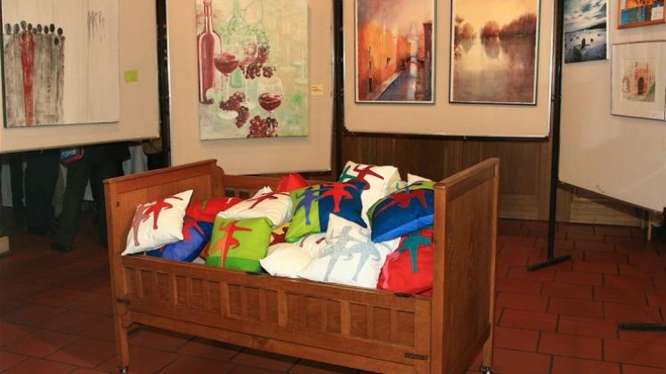 Hingucker ist das Arrangement von Bildern und Flotte-Lotte-Kissen bestücktem Bett.Fotos: Ursula Holtgrewe