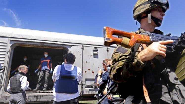 Inspektion im Kühlzug: Von Soldaten abgeschirmt, untersuchen niederländische Experten hunderte von Todesopfern des Flugzeugabsturzes in der Ostukraine. 