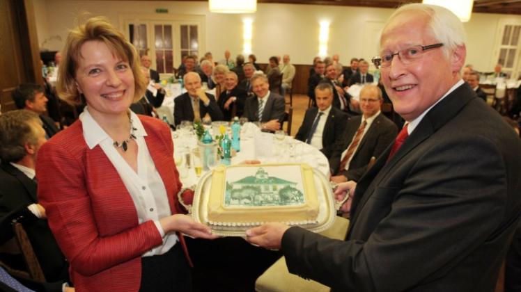 Zum Abschied überreichte Ratsvorsitzende Anette Gottlieb eine Torte, die das Bad Essener Rathaus zeigt, an Günter Harmeyer. 