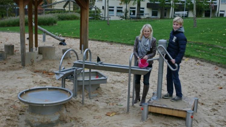 Marita Lorenz, Vorsitzende des Vereins „Kinderwelten“, und ihr Sohn Felix am neuen Wasserspiel im Familienpark Bad Essen. 