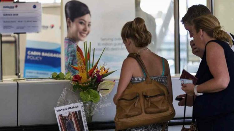 An einem Schalter der Malaysian Airlines in Amsterdam Schiphol hat jemand Blumen nach dem mutmaßlichen Abschuss von MH17 niedergelegt. Beinahe wäre auch Nour Azaani mit ihrer Familie an Bord des Fluges gewesen. 