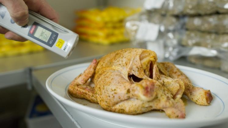Ein Lebensmittelkontrolleur überprüft die Temperatur einer Portion Hähnchen. Gstronomen fürchten eine zunehmende Gefahr durch erregerbelastetes Fleisch in ihren Küchen. 
