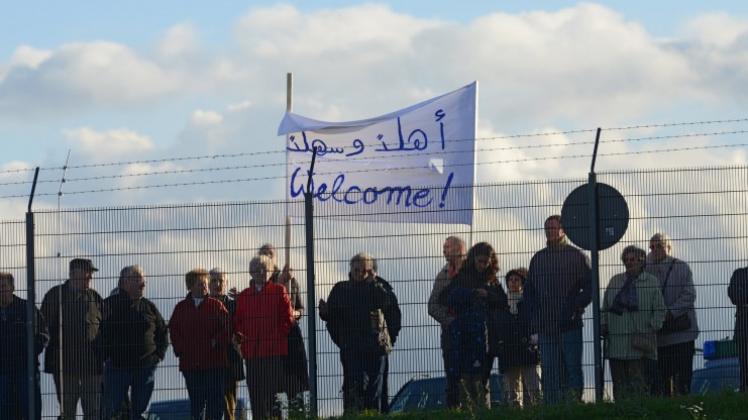 Zaungäste heißen syrische Flüchtlinge mit einem Transparent in Deutschland willkommen. 