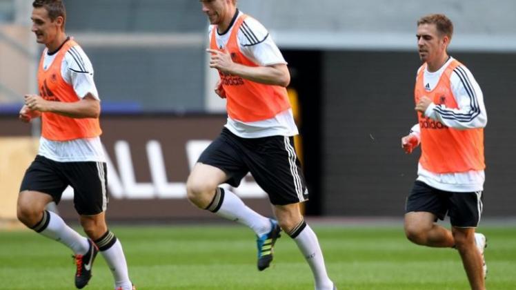 Die Nationalspieler Miroslav Klose, Per Mertesacker und Philipp Lahm (l-r) traben im Düsseldorfer Stadion gemächlich nebeneinander her. Die Nationalspieler Miroslav Klose, Per Mertesacker und Philipp Lahm (l-r) traben im Düsseldorfer Stadion gemächlich nebeneinander her.