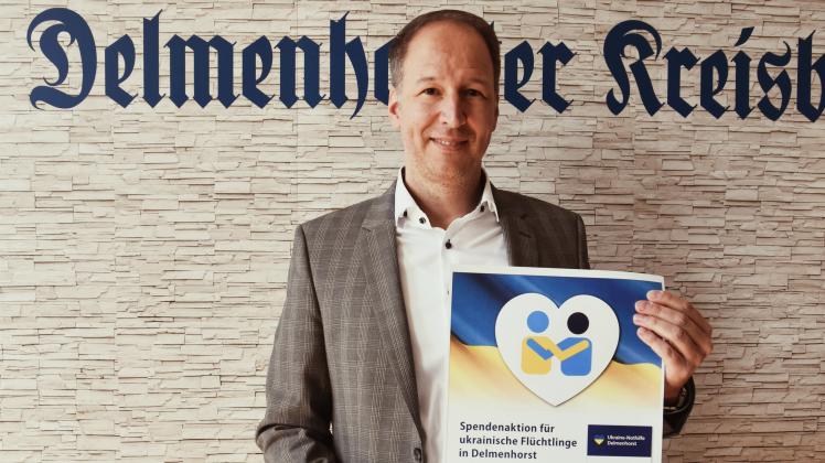 dk-Geschäftsführer Thosten Schulze mit Spendenplakat.