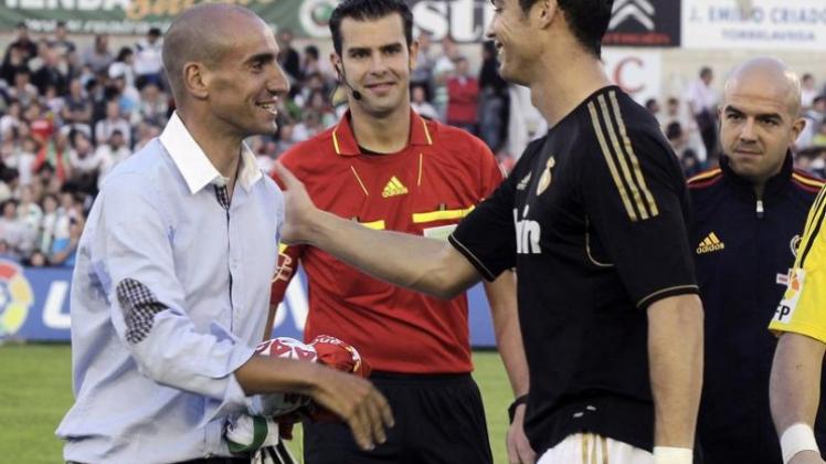 Vor der Partie begrüßt Cristiano Ronaldo (r) den spanischen Rad-Profi Juan Jose Cobo (l), der die Vuelta 2011 gewonnen hat.