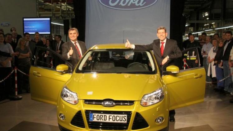 Peter Müller, Ministerpräsident des Saarlandes (links) und Ford-Deutschlandchef Bernhard Mattes fuhren das erste neue Ford Focus-Modell vom Band. (obs/Ford Werke GmbH).