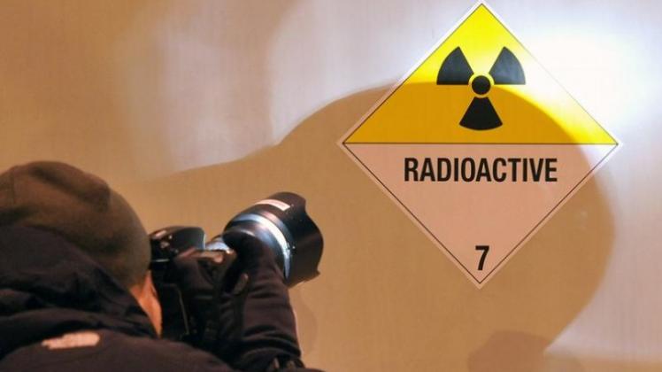 Ein Bildreporter fotografiert ein Hinweisschild an einem der Castor-Transporter mit Atommüll.