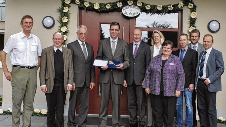 Vor dem selbst gestalteten Kranz wurde der Schlüssel zur Tagespflege St. Angela übergeben. Von links: Kirchenvorstand Hermann Schnelte, Pfarrer Johannes Bartke, Kirchenvorstand Gregor Heller, Lutz Birkemeyer (Bischöflicher Stuhl), Geschäftsführer Walter Borker, Henni Krabbe (Sozialdezernentin Landkreis Emsland), Margret Brinkmann (Mitarbeiterin Tagespflege), Michael Hengemühle (Leiter Caritas-Sozialstation Haselünne), Architekt Johannes Baune, Michael Lucas-Nülle (Caritasverband Osnabrück). Vor dem selbst gestalteten Kranz wurde der Schlüssel zur Tagespflege St. Angela übergeben. Von links: Kirchenvorstand Hermann Schnelte, Pfarrer Johannes Bartke, Kirchenvorstand Gregor Heller, Lutz Birkemeyer (Bischöflicher Stuhl), Geschäftsführer Walter Borker, Henni Krabbe (Sozialdezernentin Landkreis Emsland), Margret Brinkmann (Mitarbeiterin Tagespflege), Michael Hengemühle (Leiter Caritas-Sozialstation Haselünne), Architekt Johannes Baune, Michael Lucas-Nülle (Caritasverband Osnabrück).