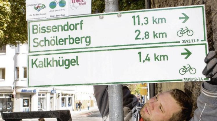 Beim Anbringen der neuen Zielwegweiser gibt es viel zu schrauben: Daniel Heiner vom Bauhof Osnabrück mit Ulla Bauer an der Kommenderiestraße. 