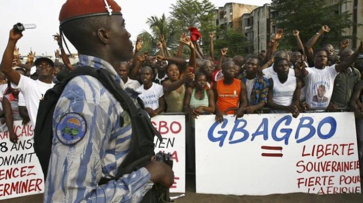 Ein ivorischer Polizist beobachtet eine Pro-Gbagbo-Demonstration in Abidjan.