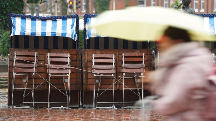 10.03.2019, Nordrhein-Westfalen, Köln: Eine Frau hält in einer Windböe am Rheinufer ihren Regenschirm fest. Foto: Oliver Berg/dpa +++ dpa-Bildfunk +++