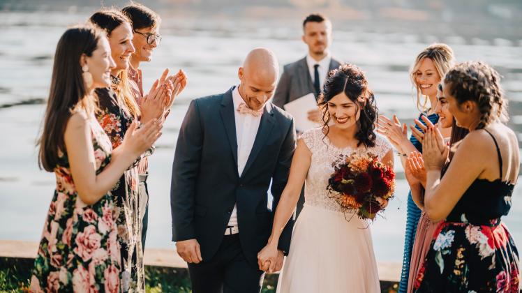 Wedding guests applauding for couple on wedding ceremony