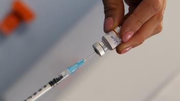 April 9, 2022, London, United Kingdom: A doctor draws the first dose of the Pfizer COVID-19 jab to be administered to a