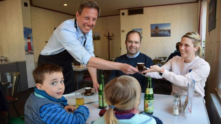 Gekonnt überreicht SPD-Spitzenkandidat Thomas Losse-Müller (l.) Bente Meier aus Osterby die Espressotasse. Gemeinsam mit Ehemann Sven und den Kindern Sverre (6) und Edda (4) besuchte sie das Restaurant Methmanns Mittagstisch, bevor es zum Flohmarkt ging.