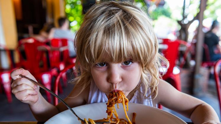 Girl eating spaghetti at restaurant model released Symbolfoto RUNF03926