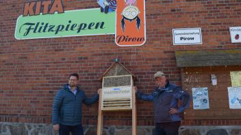 Mario Auls (l.) von der WEMAG und der Pirower Bürgermeister Uwe Kessler freuen sich über ein neues Insektenhotel. Aufgestellt wird es bei der Kita Flitzpiepen.