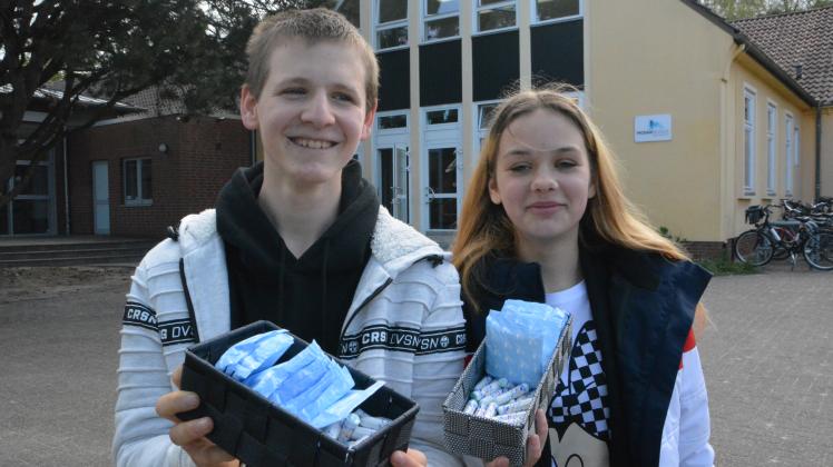 Christian Dierks und Lucy Reichel vom Delmenhorster Kinder- und Jugendparlament überreichen der Mosaikschule die ersten Boxen mit Damenhygieneartikeln. 