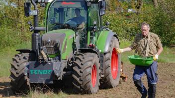 Landwirt Hannes Oetgen bereitet den Boden mit dem Trecker vor, Hegering-Vorstandsmitglied Detlef Riedel läuft hinterher und verteilt die Saat. 