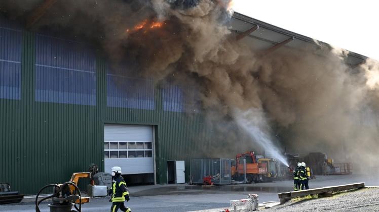 Feuerwehrleute bekämpfen den Brand einer großen Lagerhalle in Reken im westlichen Münsterland. Foto: Bludau Foto/dpa
