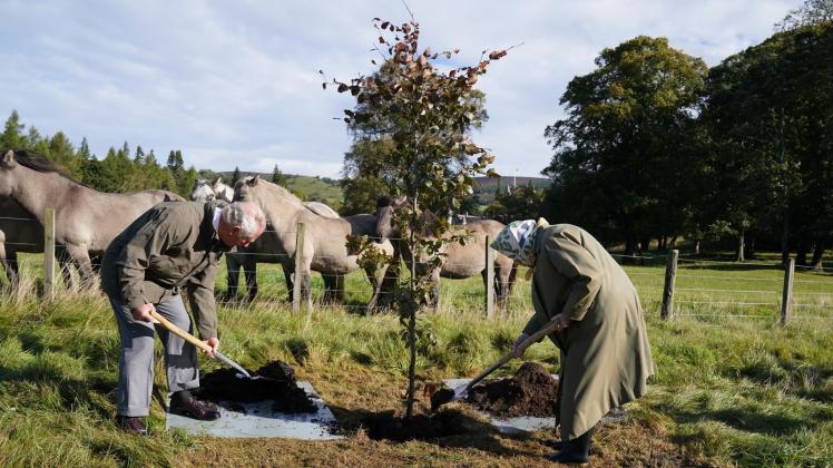 ARCHIV - Königin Elizabeth II. und Prinz Charles pflanzen 2021 auf Schloss Bamoral für «Queen&apos;s Green Canopy» einen Baum. Foto: Andrew Milligan/PA Wire/dpa