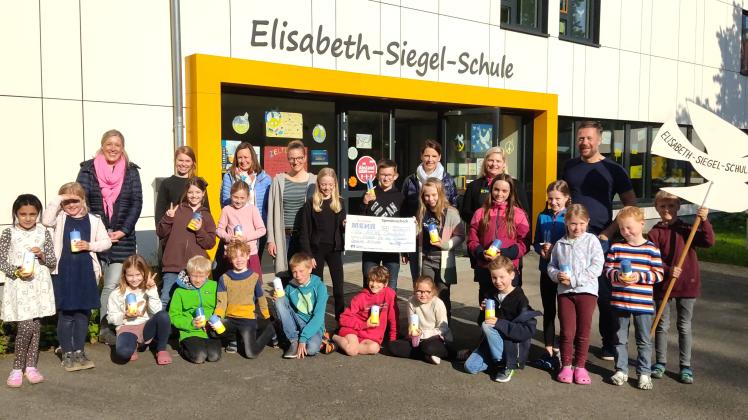 Schulleiter Till Schlaack, Eltern und Schüler der Osnabrücker Elisabeth-Siegel-Schule übergeben den Check in Höhe von 5.010 Euro an das Kinderhilfswerk „Die Arche“.