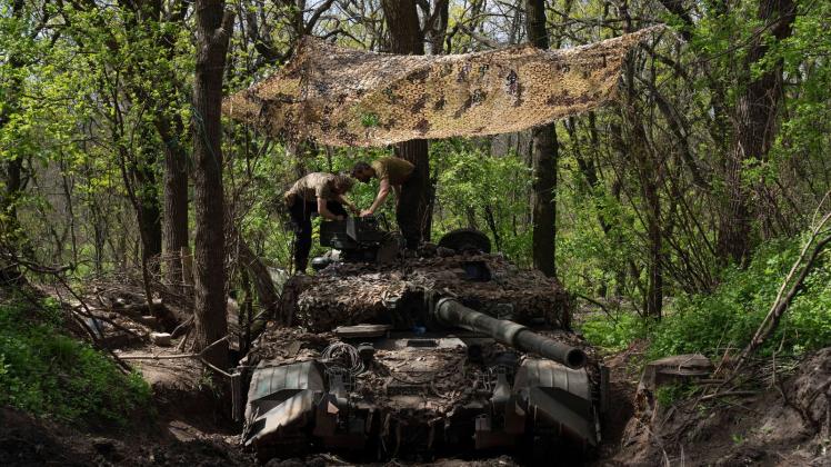 Ukrainische Soldaten installieren ein Maschinengewehr auf einem Panzer. Foto: Evgeniy Maloletka/AP/dpa