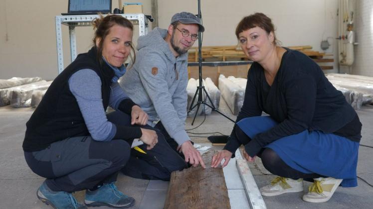 Die Wissenschaftler Tereza Stolcova vom Archäologischen Institut an der Akademie der Wissenschaft in Nitra (v.l.), Janosch Willers und Dr. Nina Lau dokumentieren die letzten Holzbalken, bevor er für die Reise in die Slowakei verpackt wird.