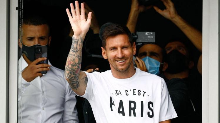 Fußballspieler Lionel Messi winkt den Fans aus einem Fenster zu, nachdem er auf dem Pariser Flughafen Le Bourget gelandet ist.