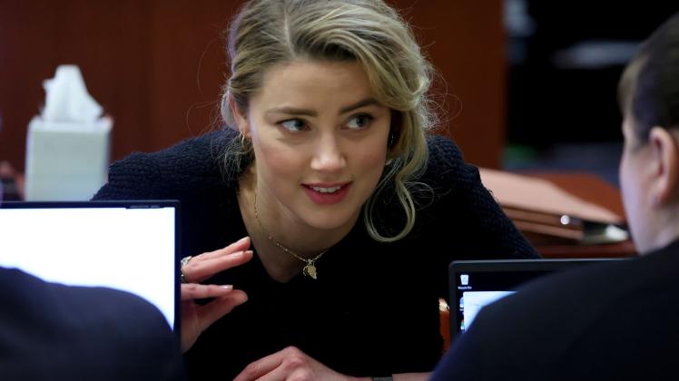 Die Schauspielerin Amber Heard bespricht sich mit ihrem Anwaltsteam. Foto: Michael Reynolds/EPA Pool/AP/dpa