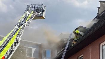 Ein Feuerwehrmann versucht, die Wohnung und den Bewohner durch ein Dachgeschossfenster zu erreichen.