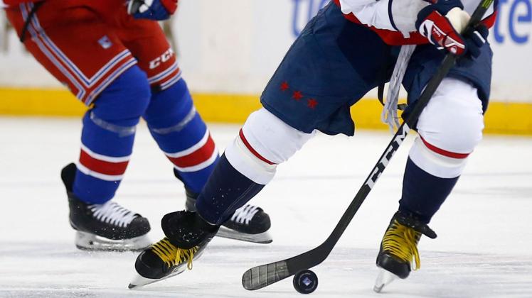 ARCHIV - Zwei Eishockeyspieler kämpfen um den Puck. Foto: John Munson/AP/dpa/Symbolbild ARCHIV - Zwei Eishockeyspieler kämpfen um den Puck. Foto: John Munson/AP/dpa/Symbolbild