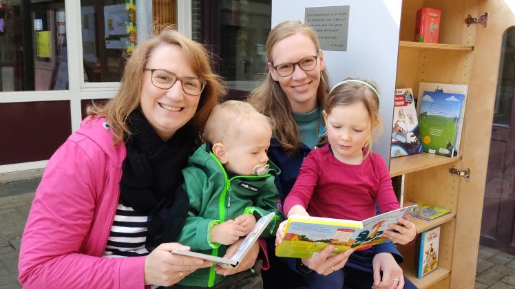 Magdalena Knappik und Ann-Kathrin Tebbe vom Förderverein der Kita St. Wiho mit ihren Kindern Julian und Louisa am neuen Bücherschrank.