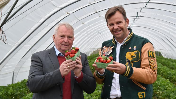 Landwirtschaftsminister Backhaus (links) und Robert Dahl, Geschäftsführer von Karls Erdbeerhof, sind mit den ersten Erdbeeren des Jahres sichtlich zufrieden.