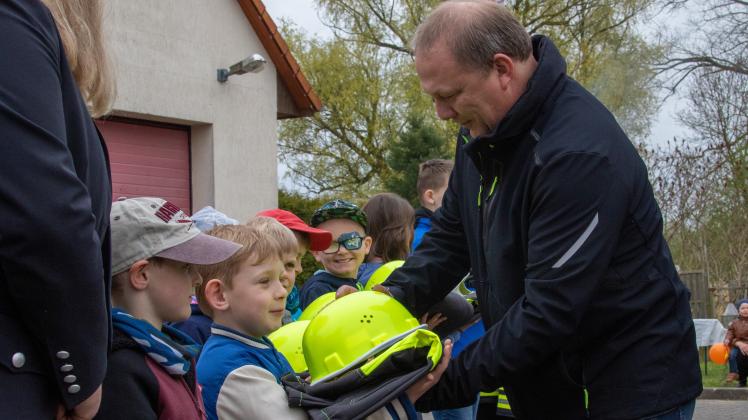 Frank Siekmann  von der Jagdgenossenschaft Tarnow übergibt an die Kinder die Feuerwehrkleidung