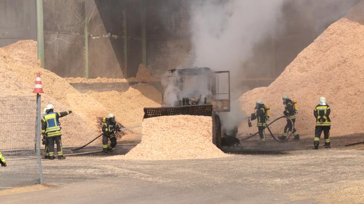 Löscharbeiten der Feuerwehr am ausgebrannten Radlader im Hagenower Holzwerk HMS. 